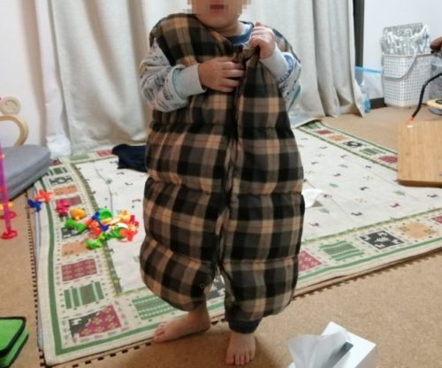ヌクンダウンスリーパーSサイズを着て立っている4歳児